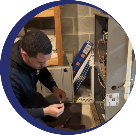 someone kneeling in front of a heating unit with tools